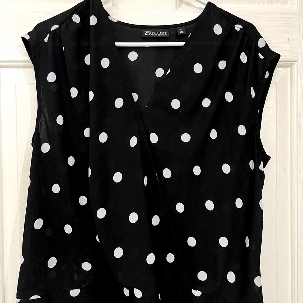 Sleeveless black and white polka dot blouse